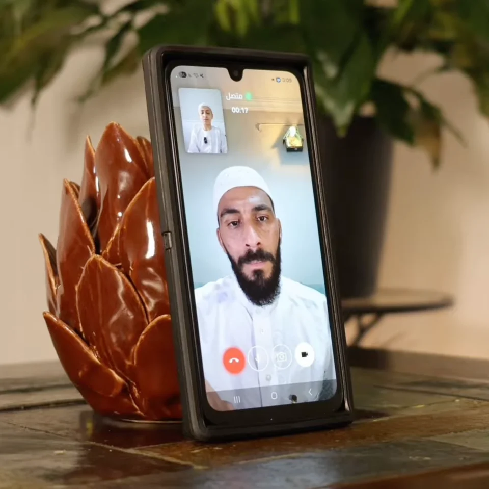 هاتف يعرض جلسة قرآن مباشرة على محراب بين معلّم وطالب